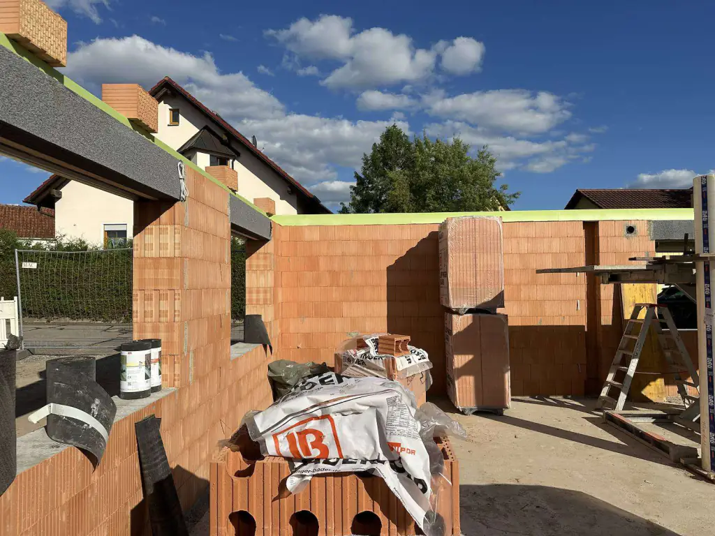 Ziegelmauerwerk im Rohbau eines Mehrfamilienhauses unter blauem Himmel